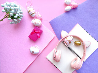 Pink Desktop. Notebook on the table with easter decorations. Frame border flat lay copy space top view. 