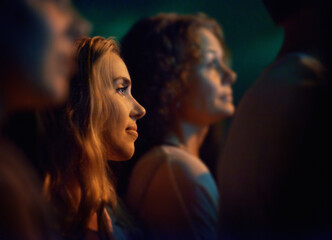 Young woman looking at the stage at a concert. This concert was created for the sole purpose of...