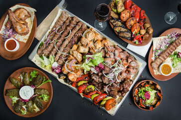 Many types Georgian shish kebab, Mtsvadi with sauce and onion. Georgian cuisine. A large laid table of different dishes for the whole family on a day off.