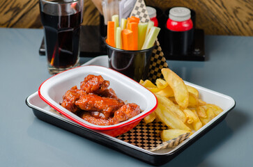 Sour-sweet baked chicken wings and sauce.