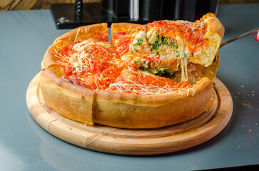 Chicago pizza with salmon, spinach, broccoli, mozzarella cheese, branded peeled tomato sauce and...