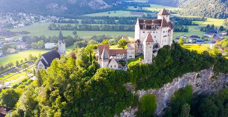 View from drone of stone Gutenberg Castle on top of green hill on background with small town of Balzers, Liechtenstein - obrazy, fototapety, plakaty