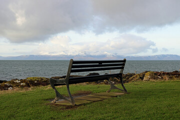 Fototapeta na wymiar Public Bench Overlooking the Isle of Arran in Scotland