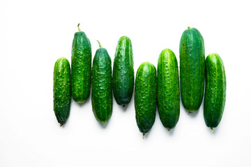 A pattern of fresh green cucumbers on a white background. Top view