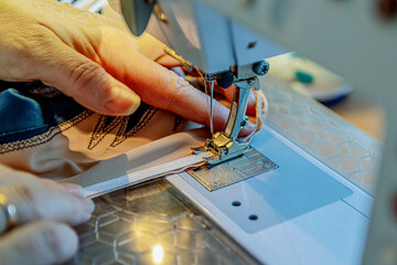 Close-up sewing process. The hands of the master, the material and equipment in the frame. Soft...