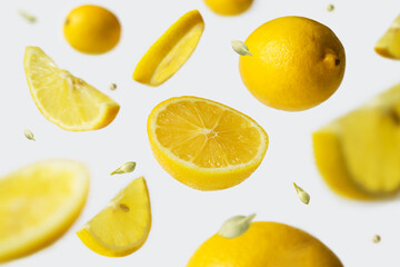 Fototapeta na wymiar Whole and sliced lemons falling in the air. Food levitation.