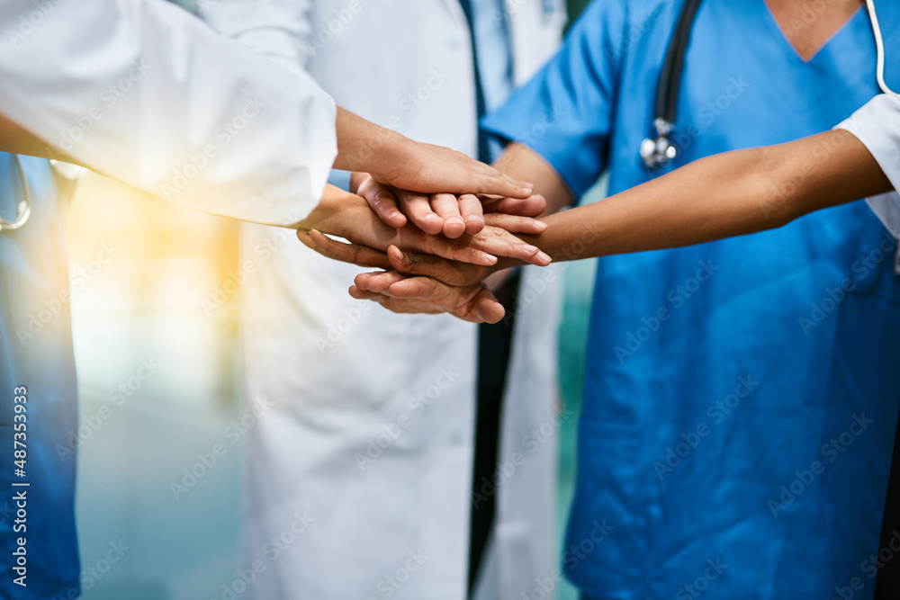 Poster in it to saves lives together. shot of a group of unrecognisable medical practitioners joining their