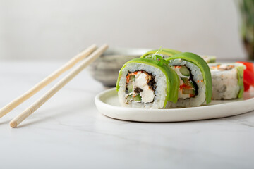 Close up of Sushi with cheese and fish on plate chopsticks