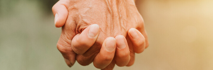 happy senior couple holding hands. hands of man and woman hold each other. romance and love and support in elderly family. husband and wife travel together in nature. countryside life. banner. flare