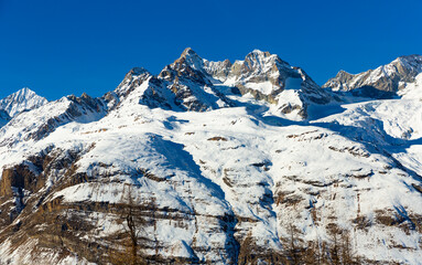 Picturesque views on highlands of Pennine Alps near Zermatt in Switzerland with snowy rocky peaks in bright winter sun