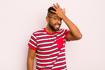 young afro man raising palm to forehead thinking oops, after making a stupid mistake or...