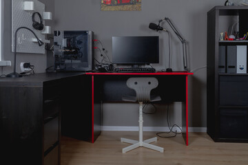 Workplace of a teenage boy with a black and red desk, computer and chair