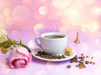 Fototapeta na wymiar Black aromatic coffee in a white cup on a lilac table. Pink rose next to the cup. Coffee beans in the background. Golden bokeh on the background