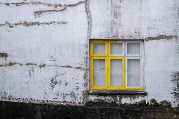 Fototapeta na wymiar Teilweise gelb angestrichenes Fenster in Reykjavik