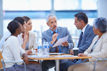 Sitting down to strategize. A cropped shot of a diverse group of businesspeople having a meeting.