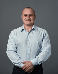 Senior businessman with arms crossed, over gray background