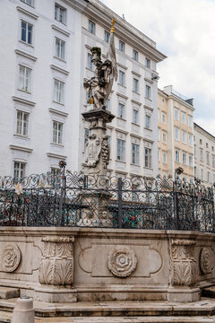 Salzburg, Austria, 28 August 2021: baroque statue, fountain Florianibrunnen at old market square, Alter Markt, renaissance and baroque houses in historic center in medieval city at summer day