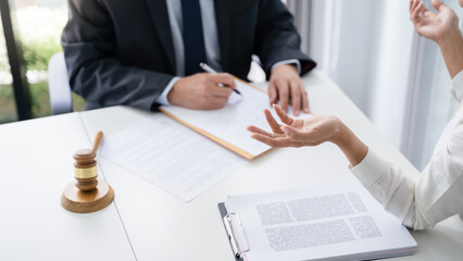 Legal counsel presents to the client a signed contract with gavel and legal law. justice and lawyer concept