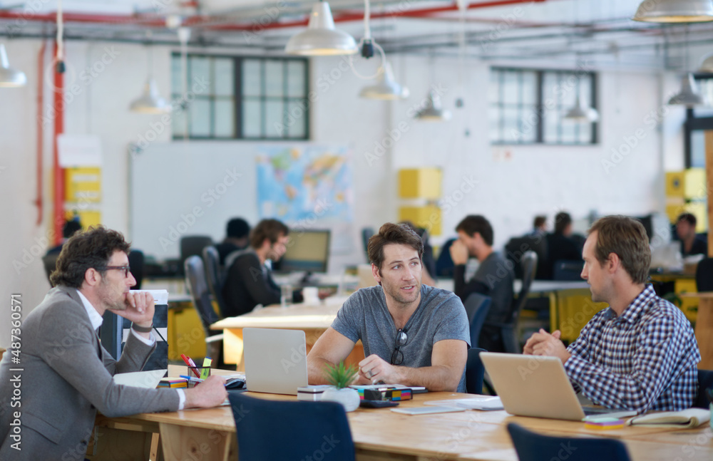 Poster we make technology work for us. shot of business colleagues discussing matters with the help of wire