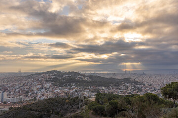 Panorama of Barcelona from the air in the early morning. City with shadows from the clouds. Dramatic sky over the city. Autumn in Barcelona, Spain.