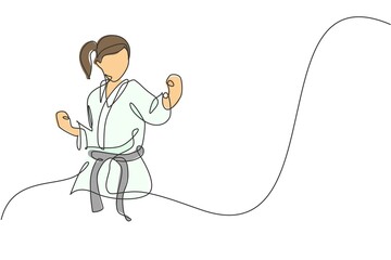 One continuous line drawing of young talented karateka girl train pose for duel fighting at dojo gym center. Mastering martial art sport concept. Dynamic single line draw design vector illustration