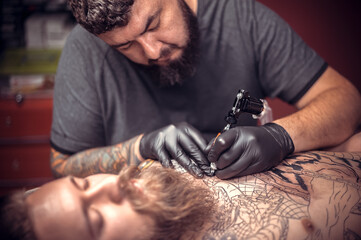 Tattoo specialist making tattoo art in salon