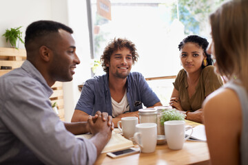 Catching up with old friends. Shot of a group of friends talking in a cafe.