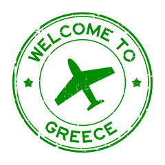 Grunge green welcome to Greece word with airplane icon round rubber seal stamp on white background