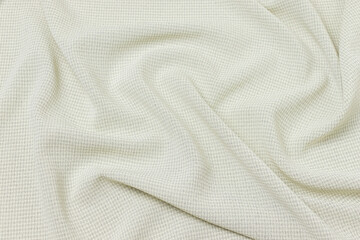 Mauled cream-colored fabric texture background. This fabric is made of cotton and polyester.