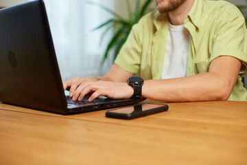 Man hands typing something on laptop, working on computer