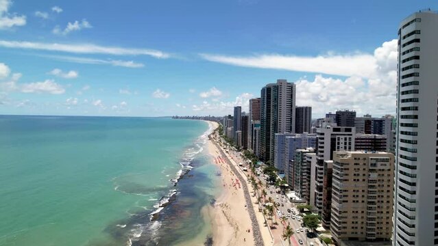 Aerial Pass by Tropical Coastal City Skyline of Recife Brazil Clear Aquamarine Ocean Waters on Bright Summer Day Drone 4k