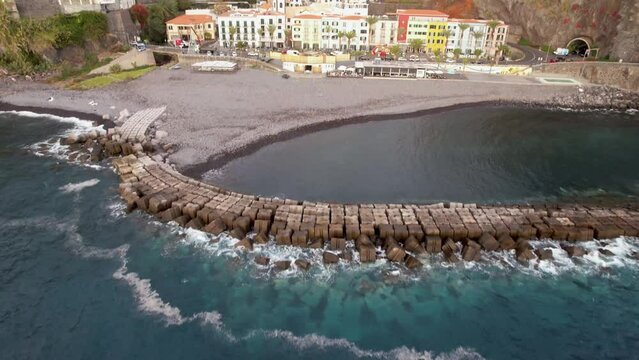 Aerial Fast Pan Up Revealing Colorful Colonial Portuguese Village of Ponta do Sol Madeira Island Portugal on Cloudy Day Drone 4k
