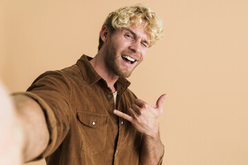 White blonde man gesturing while taking selfie photo