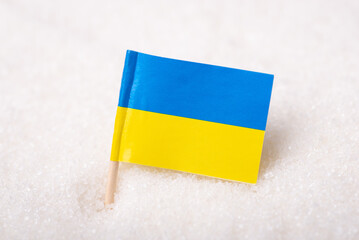 Close-up shot of flag of Ukraine in granulated sugar. Production of white sugar from sugar beets in...