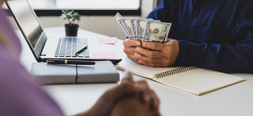 The young man waited to receive salary or wages from the boss. Businessman holding cash banknotes...