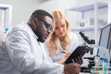 Professional team of scientists is working on a vaccine in a modern scientific research laboratory. Genetic engineer workplace. Future technology and science.