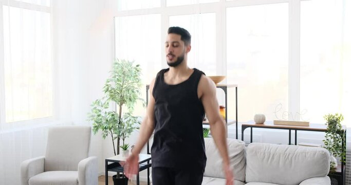 Man doing jumping jack exercise at home