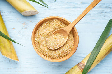 Sugarcane and brown sugar on a wooden background. Top view.