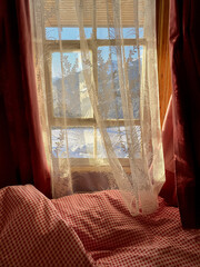 Wunderschönes Sprossenfenster auf Berghütte, transparenter Vorhang zugezogen, Blick auf Schneelandschaft mit Berg.