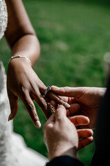 Groom puts a wedding ring on his bride's finger during the wedding ceremony Marriage concept Groom puts Wedding Ring on Bride's finger on Wedding Ceremony Exchange of rings