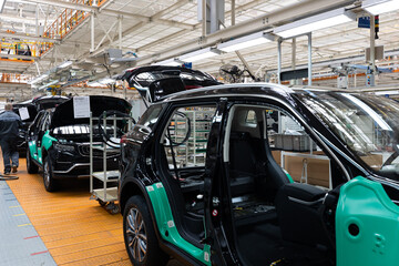 Car bodies are on assembly line. Factory for production of cars. Modern automotive industry. A car being checked before being painted in a high-tech enterprise