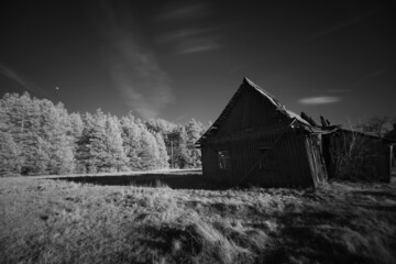 Old abandoned damaged wooden house in black and white