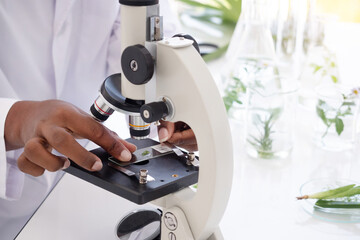 Close-up microscope. Scientist hands with microscope shot in the laboratory.