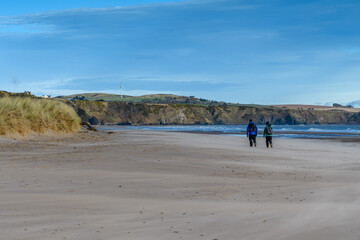 A couple walking on a windy beach