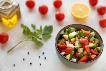 Tomato and cucumber salad. Fresh vegetable cut in cubes with lemon juice mixed in bowl.