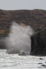 Big waves crushing on rocks at the famous red beach in Santorini Greece
