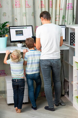 Father with kids working from home at standing desk