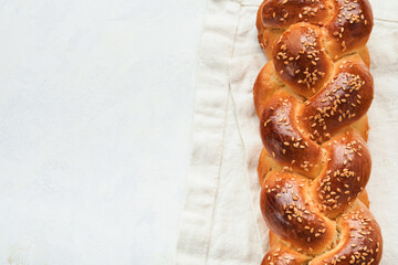 Challah bread. Sabbath kiddush ceremony composition. Freshly baked homemade braided challah bread for Shabbat and Holidays on white background, Shabbat Shalom. Top view. Copy space. - obrazy, fototapety, plakaty