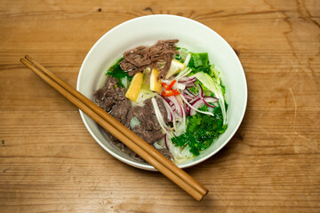 Pho Bo - Vietnamese fresh rice noodle soup with beef, herbs and chili. Vietnam's national dish.
