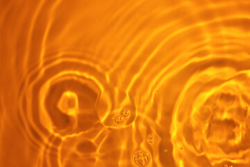 The texture of circles on water. Drops of liquid on orange background. Perfect backdrop for design projects. Summer holidays, laboratory analysis and research concept